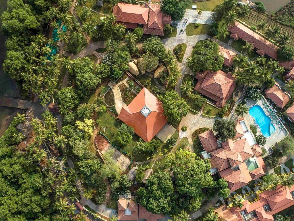 an overhead view of a resort with a pool and trees at Mercure Goa Devaaya Resort in Old Goa