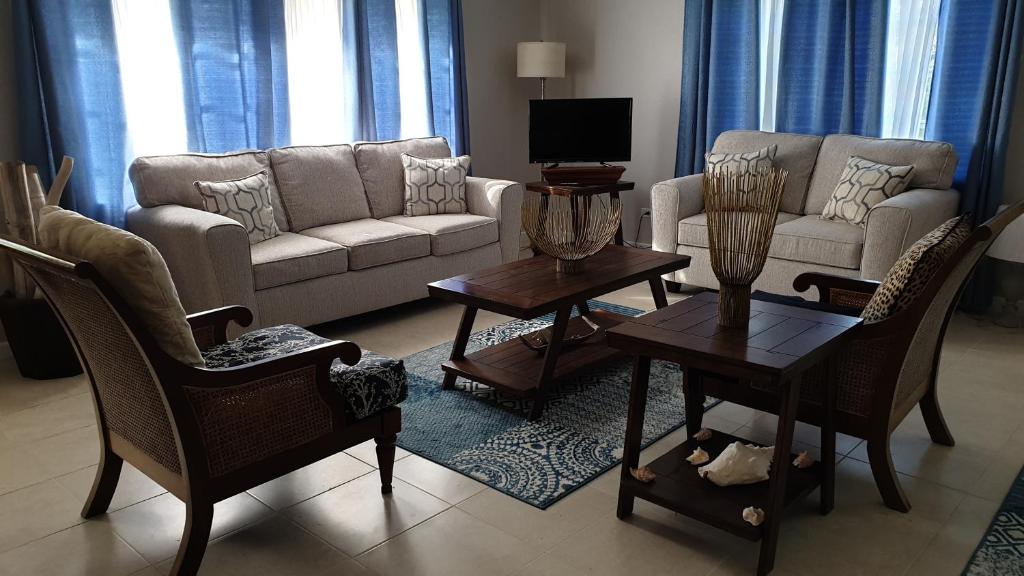 a living room with a couch and tables and chairs at Bahama Breezes in Georgetown