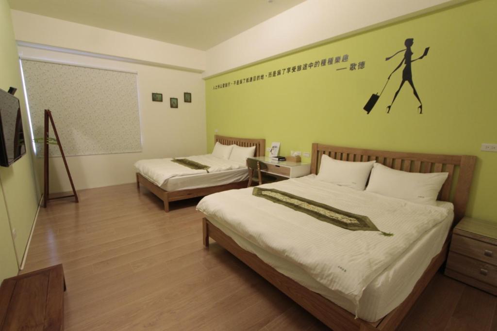 a hotel room with two beds and a sign on the wall at Jin Du Yi Yuan B & B in Hualien City