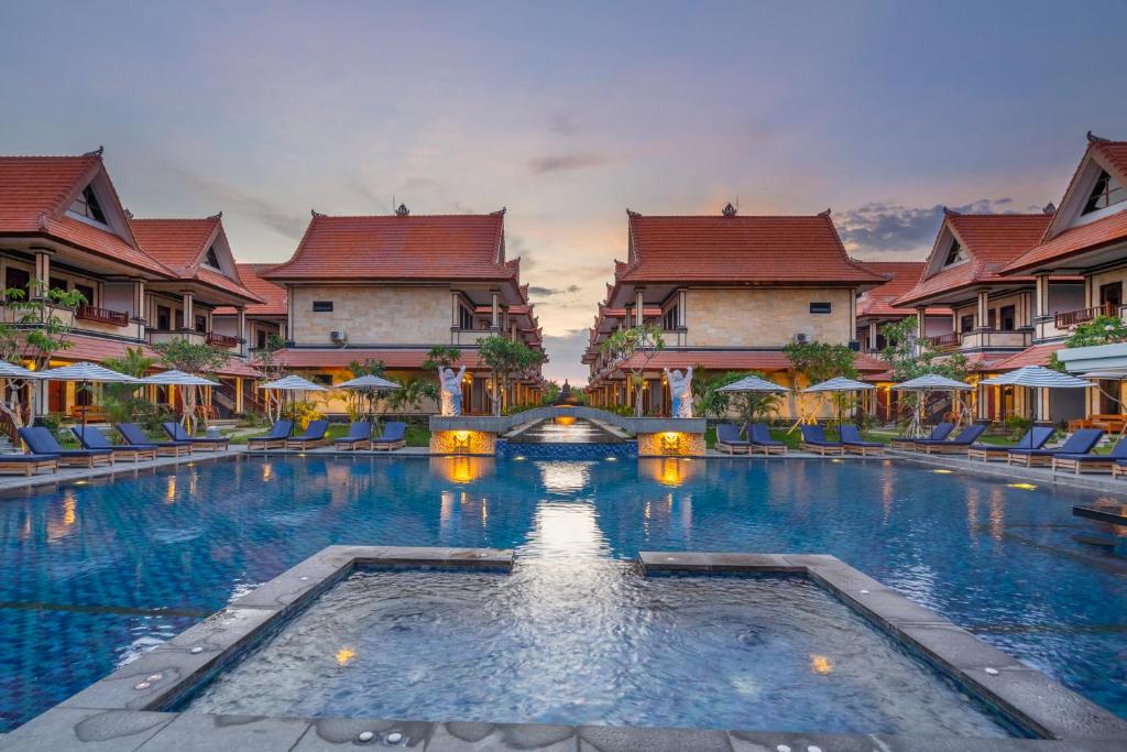 a large swimming pool in front of some buildings at The Salila Beach Resort in Seminyak