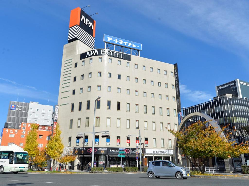 un'auto è parcheggiata di fronte a un edificio di APA Hotel Toyohashi-Ekimae a Toyohashi