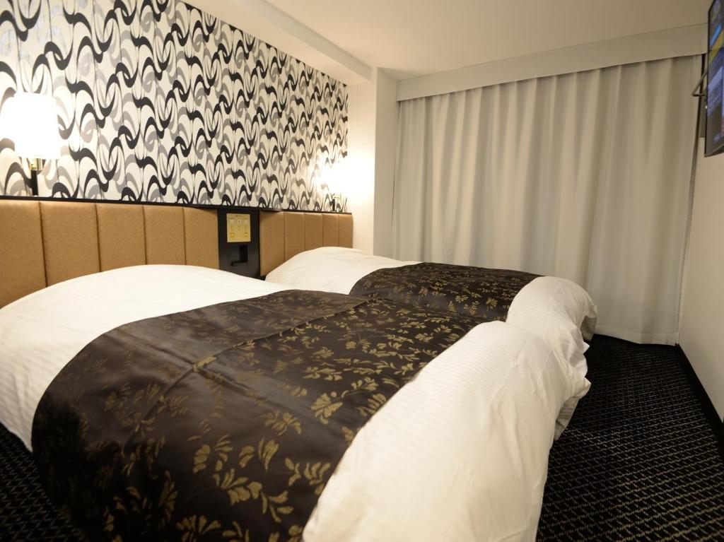 Postel nebo postele na pokoji v ubytování APA Hotel Toyohashi-Ekimae