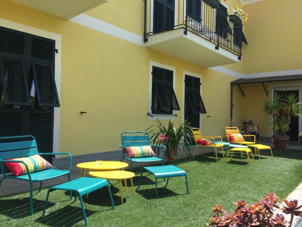 eine Terrasse mit bunten Stühlen und Tischen sowie ein Gebäude in der Unterkunft Oasi Hotel in Levanto