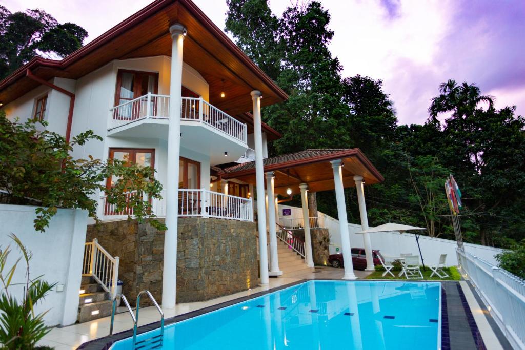 a villa with a swimming pool and a house at Orchid Villa Kandy in Kandy