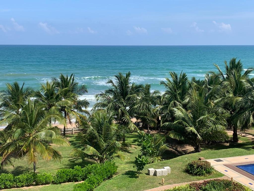 a view of the ocean from a resort with palm trees at Araliya OceanFront Condos Nilaveli, Trincomalee in Nilaveli