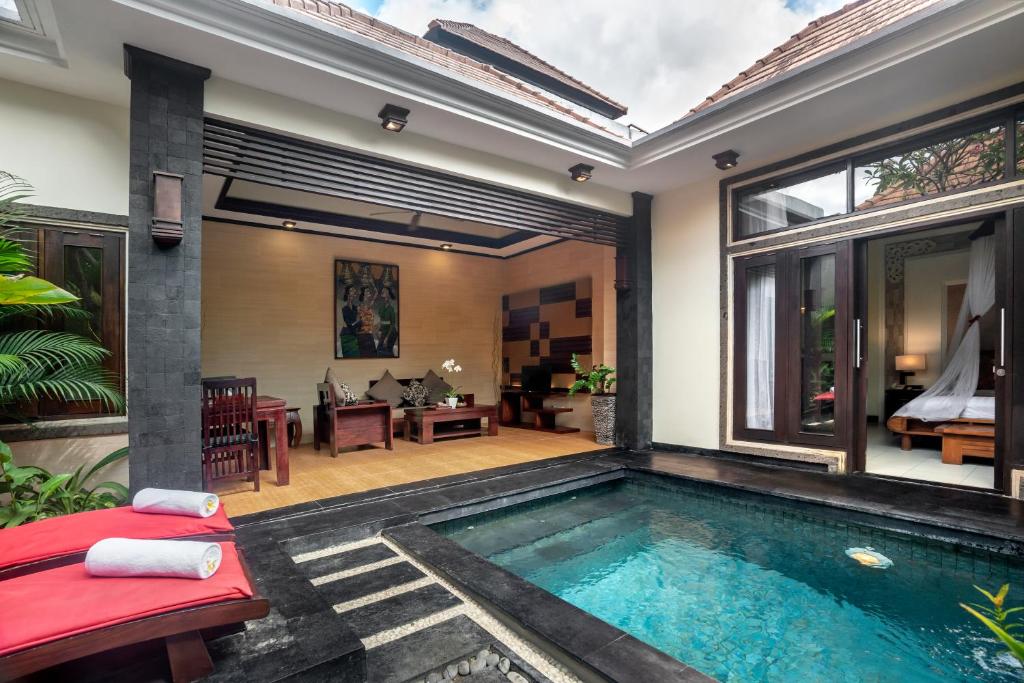 a swimming pool in a villa with a patio at The Bali Dream Villa Seminyak in Seminyak
