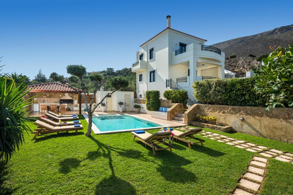 a villa with a swimming pool and a house at Villa Georgia Heated Pool & Jet-Tub in Kolymvari
