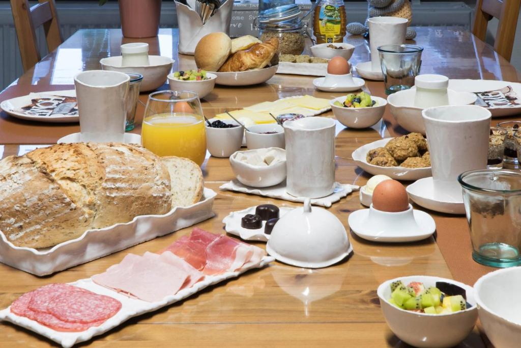 un tavolo con colazione a base di pane, uova e cibo di B&B De Oude Berg a Mol