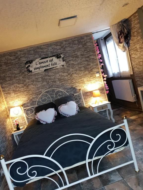 Le Breuil-en-AugeにあるChambre d'hôte la romance IIのベッドルーム1室(黒いベッド1台、枕2つ付)
