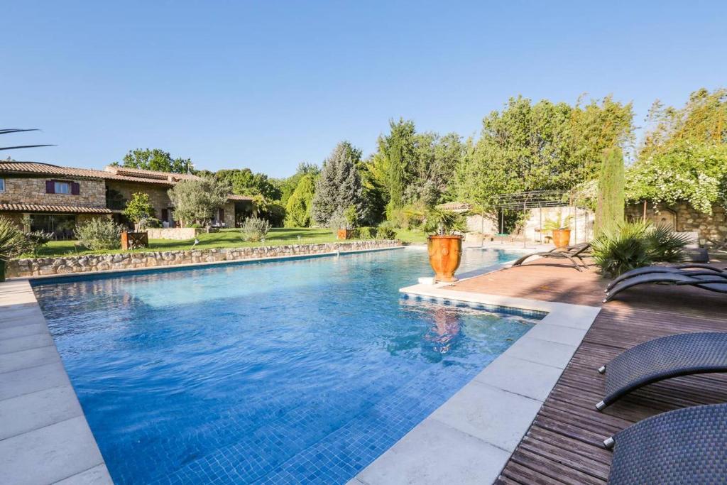 - une grande piscine d'eau bleue dans la cour dans l'établissement Gite au coeur de la Provence & SPA, à Saint-Cannat