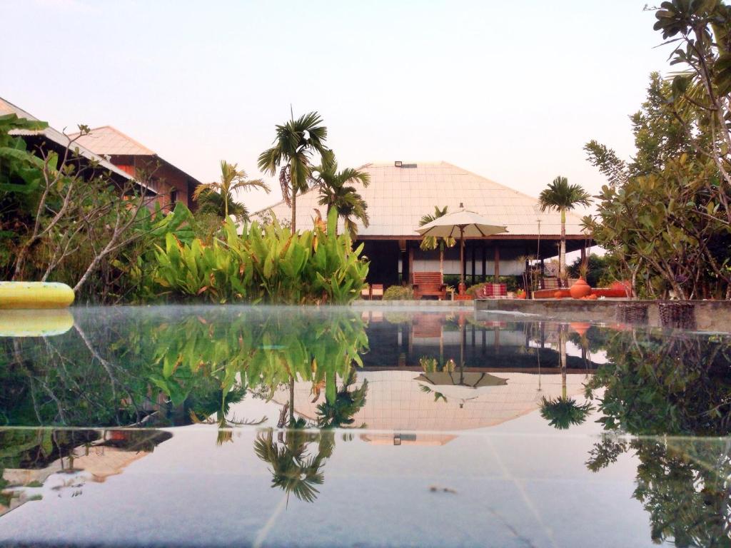 a pool of water in front of a resort at BaanSuk Sukhothai Resort in Sukhothai