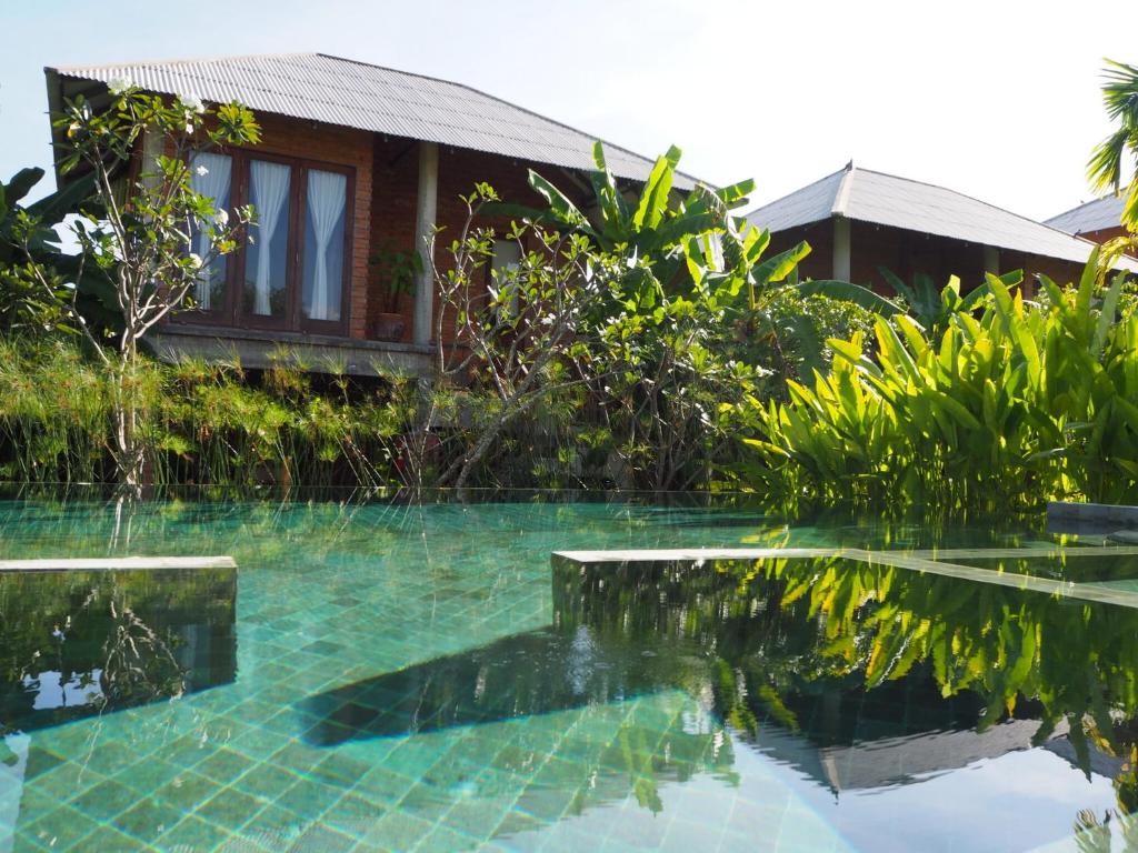 a swimming pool in front of a house at BaanSuk Sukhothai Resort in Sukhothai