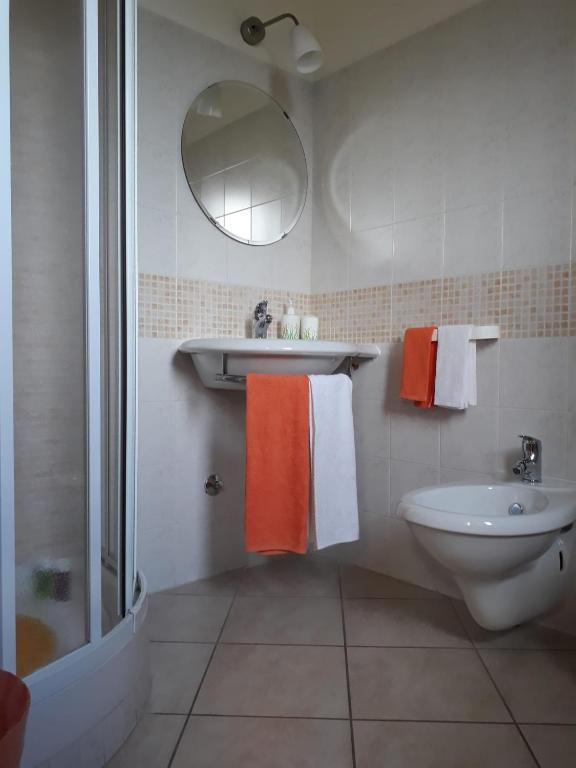 bagno con asciugamani arancioni e bianchi e lavandino di Il Faggio 17 B&B ad Artena