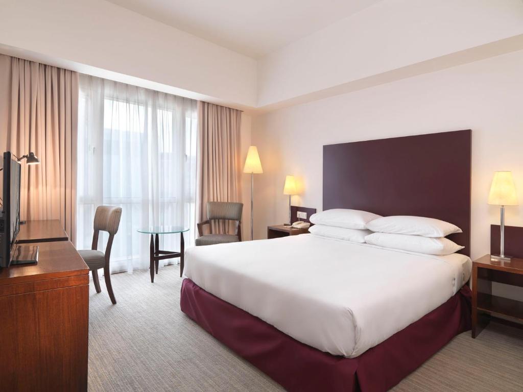 クアラルンプールにあるキャピトル ホテル クアラ ルンプールの大型ベッドとテレビが備わるホテルルームです。