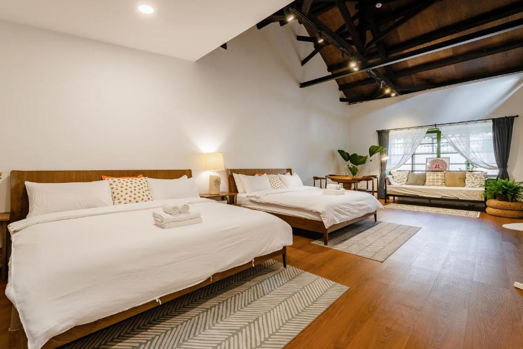 1 dormitorio con 2 camas y sofá en Hearty Cottage, en Hualien City