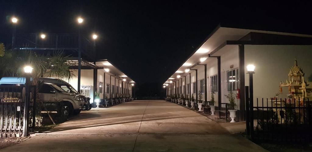 una calle oscura por la noche con una fila de edificios en บ้านเชียงรายรีสอร์ท Baan Chiangrai Resort en Chiang Rai