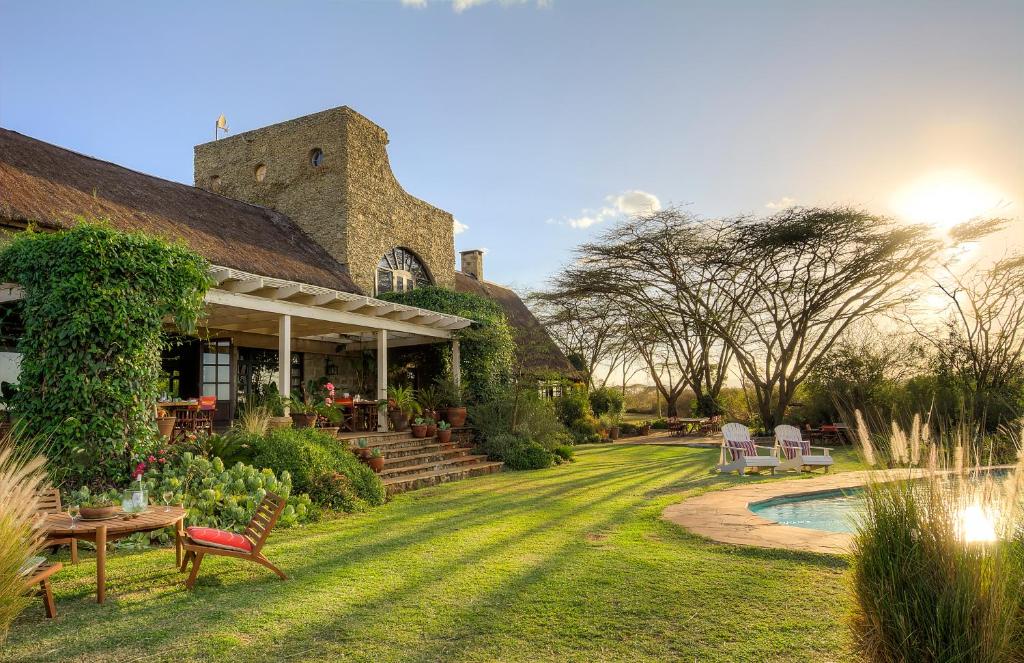 a house with a yard with a swimming pool at Ololo Safari Lodge in Nairobi