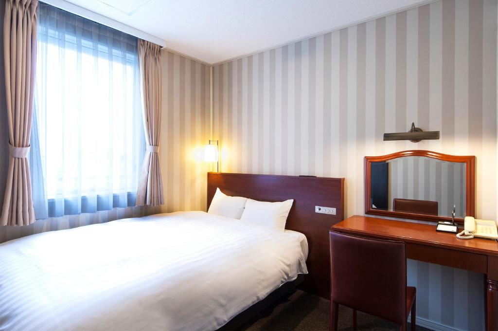 Postel nebo postele na pokoji v ubytování TsukubaNoYu Urban Hotel