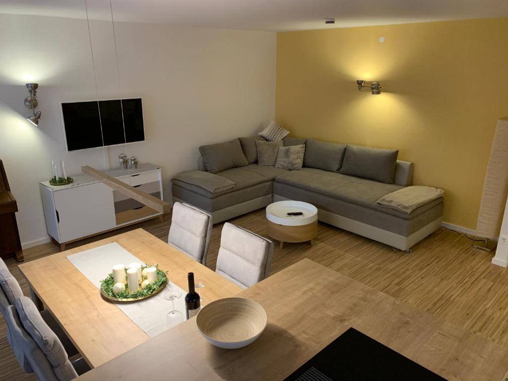 ein Wohnzimmer mit einem Sofa und einem Tisch in der Unterkunft Moderne Ferienwohnung nahe SWR und Golfplatz in Baden-Baden