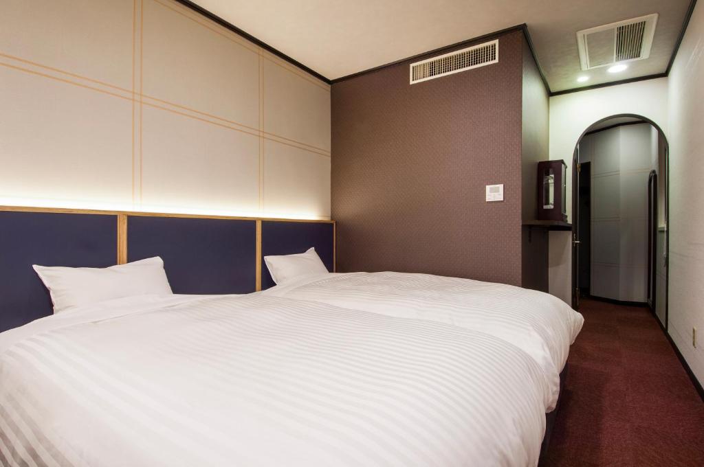 Postel nebo postele na pokoji v ubytování TsukubaNoYu Urban Hotel