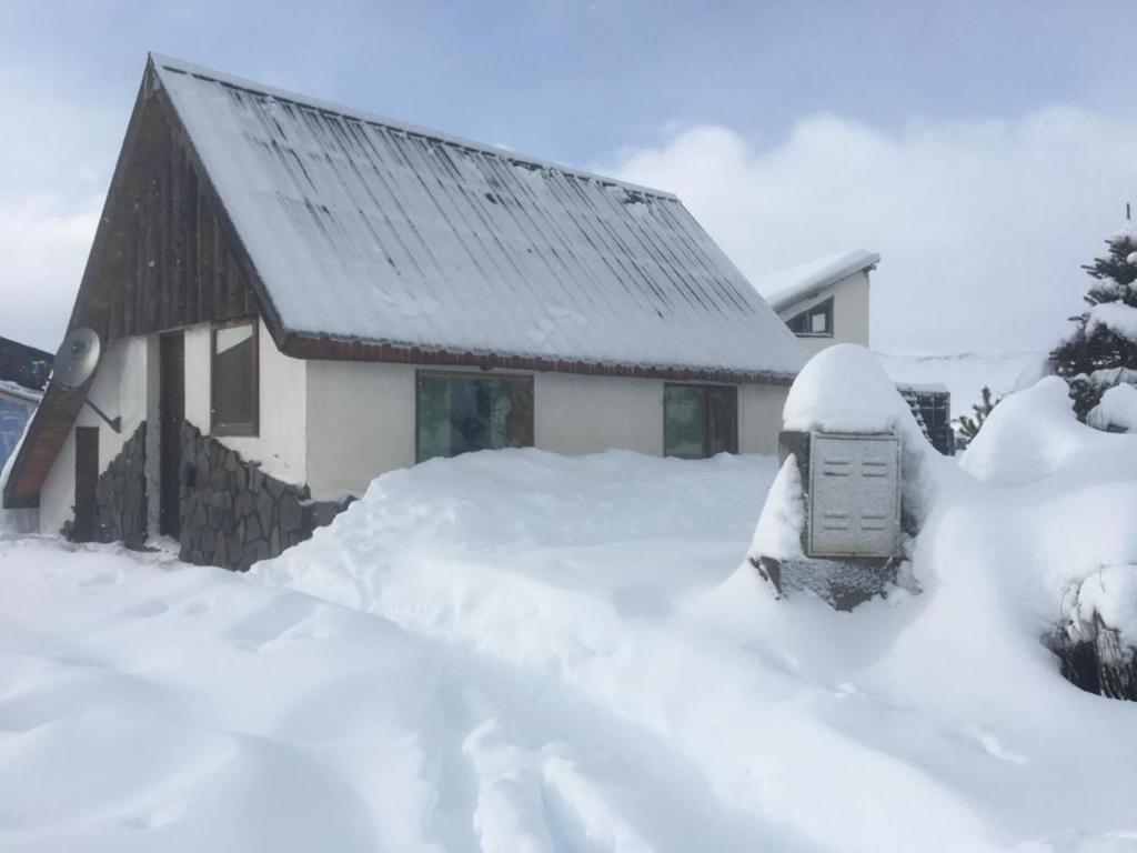ein schneebedecktes Haus mit Parkuhr in der Unterkunft Cabaña en Caviahue in Caviahue