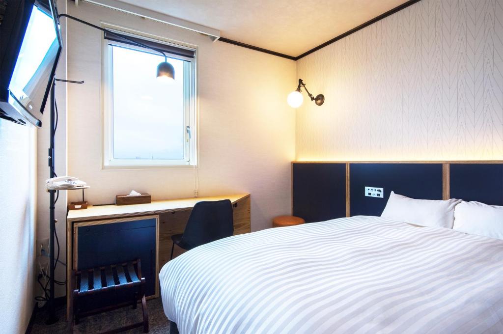 Postel nebo postele na pokoji v ubytování TsukubaNoYu Urban Hotel
