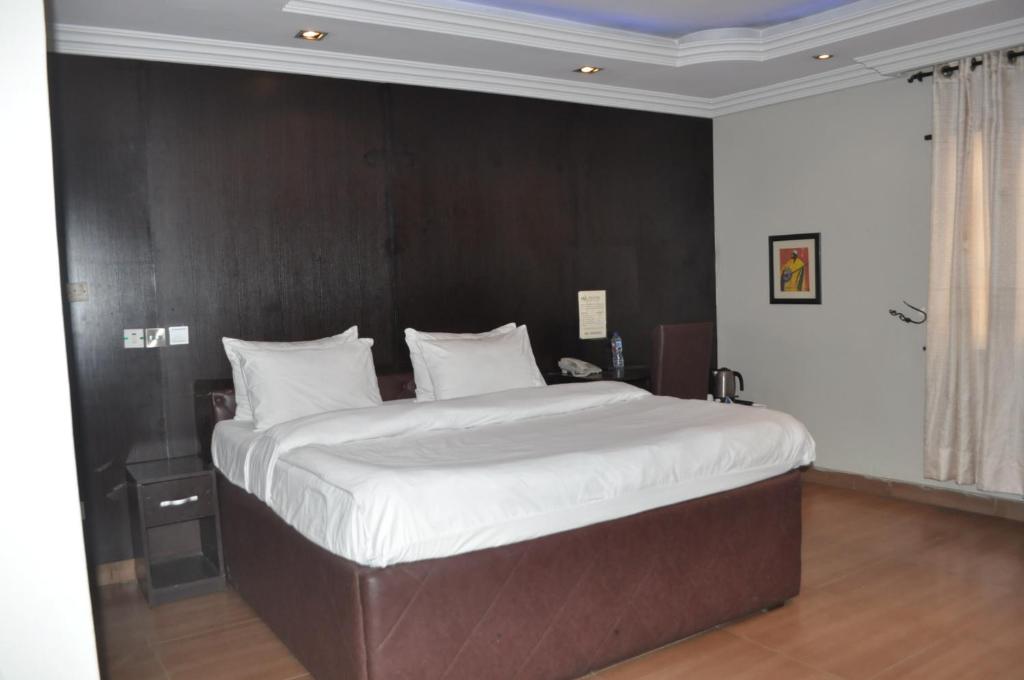 Postel nebo postele na pokoji v ubytování Triple Tee Hotel