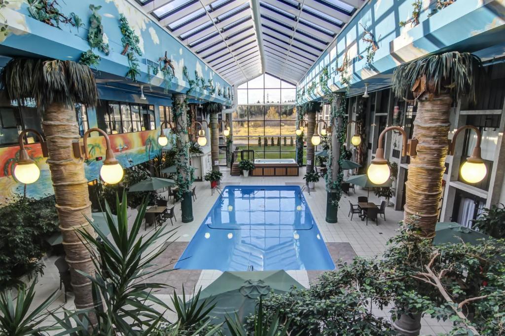 un jardin intérieur avec une piscine dans un bâtiment dans l'établissement La Saguenéenne - Hôtel et Centre de Congrès, à Saguenay