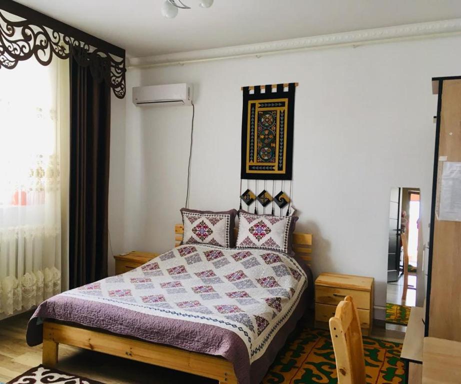 a bedroom with a bed with a purple comforter at Guest House EtnoDom in Jalal-Abad