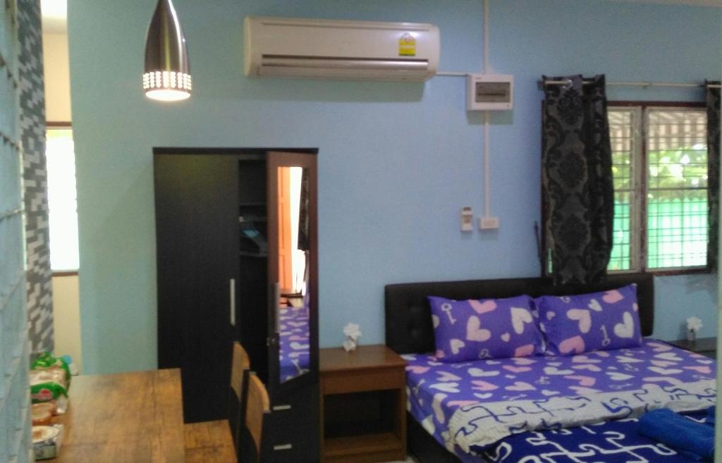 a small bedroom with a bed and a table at Studio with aircon n kitchen in Bang Tao Beach