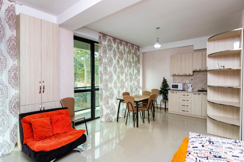 a kitchen and dining room with an orange chair and a table at Apart 516 Bobline in Bakuriani