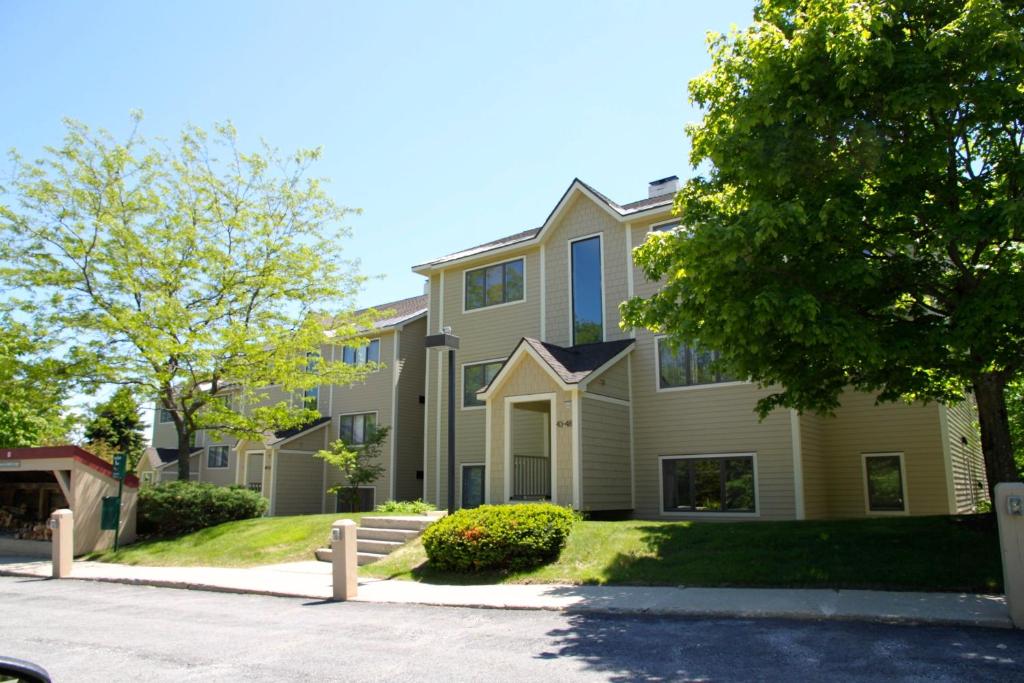 a large house with a tree in front of it at Vantage Point Villas at Stratton Mountain Resort in Stratton Mountain