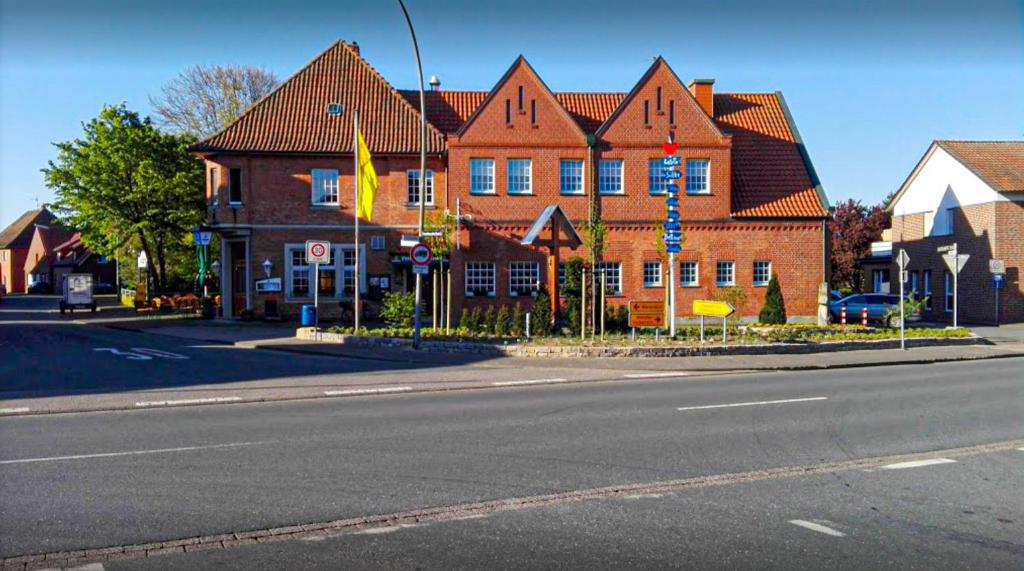 een groot bakstenen gebouw aan de kant van een straat bij Gasthof-Hotel Biedendieck in Warendorf
