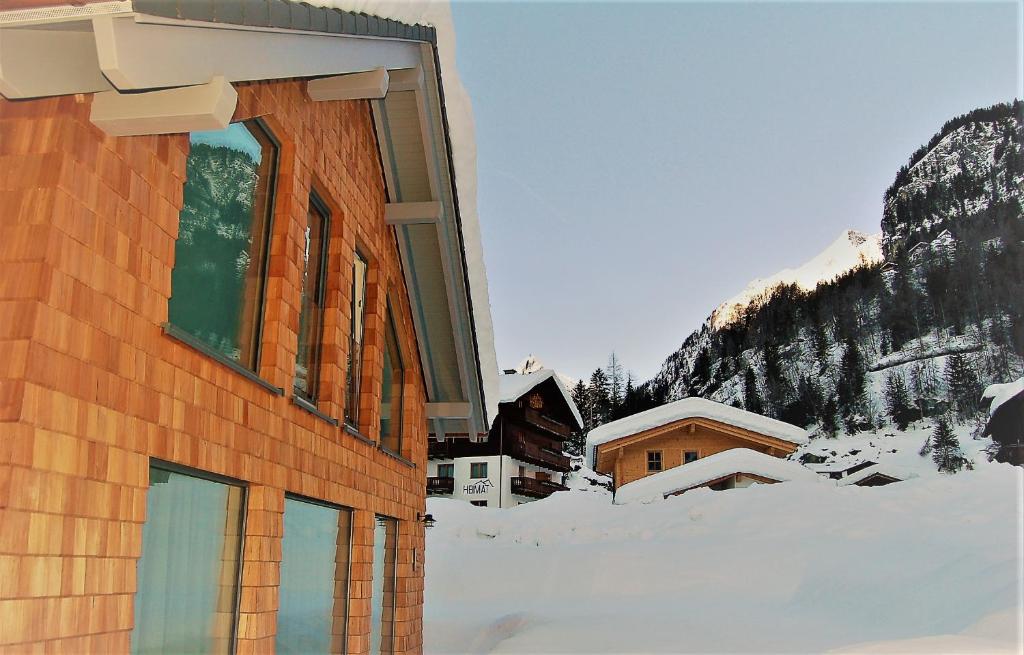 un edificio con nieve frente a una montaña en Virgentaler Alp, en Prägraten am Großvenediger