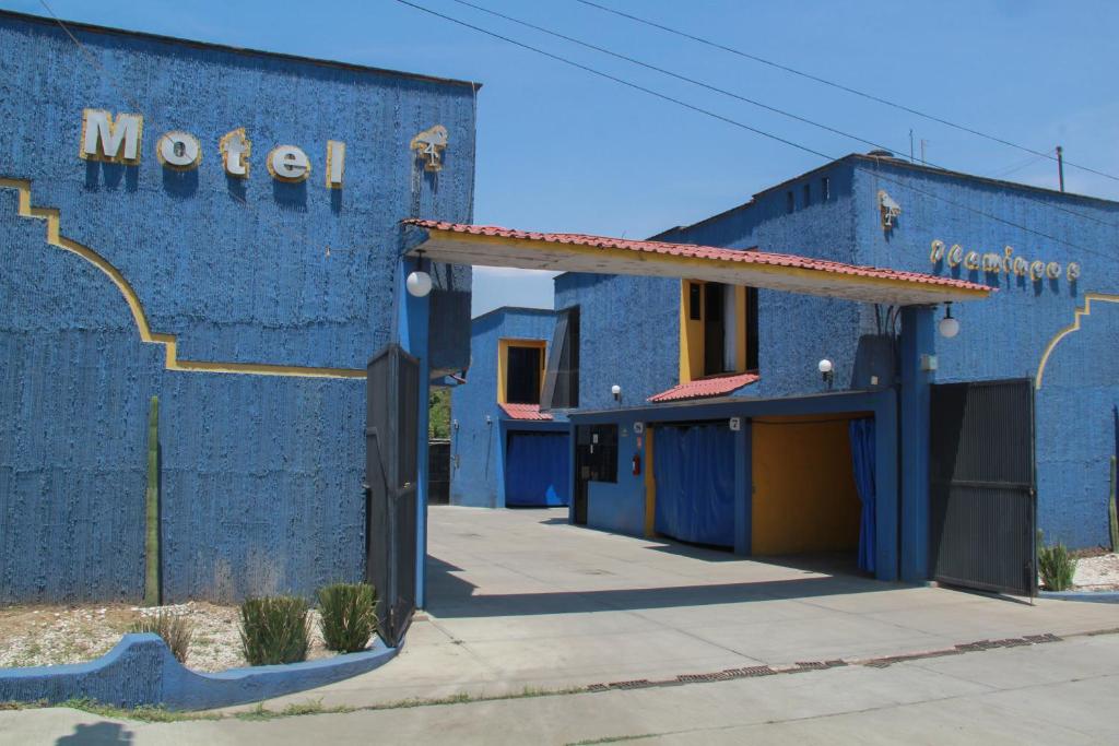een blauw gebouw met een bord dat het motel leest bij Motel Flamingos in Oaxaca City