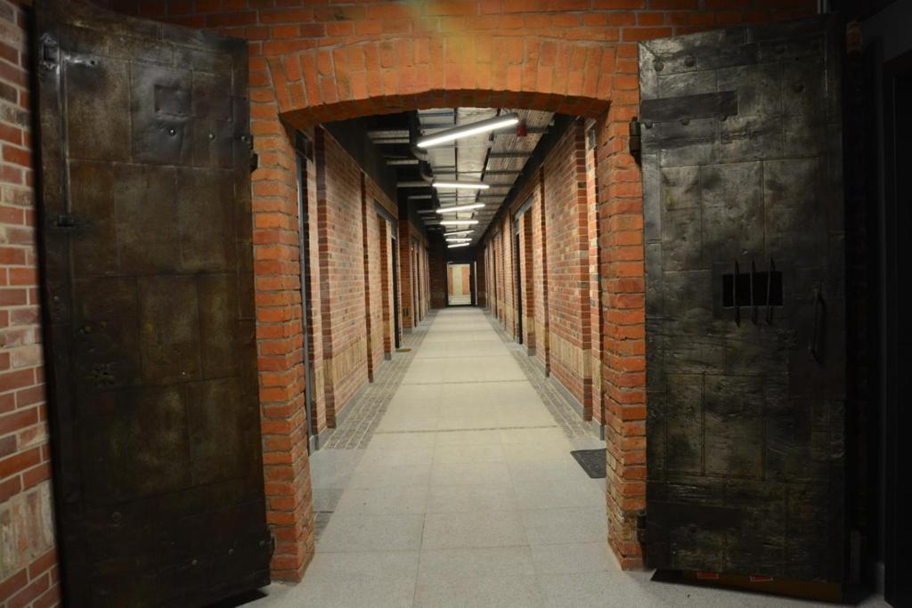 un callejón con una pared de ladrillo y dos puertas abiertas en LoftStyle Apartament 2, en Żyrardów