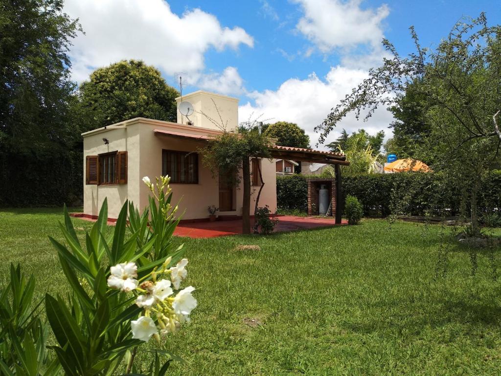 una pequeña casa en un patio con césped verde en Cabaña El Canal en Villa Carlos Paz