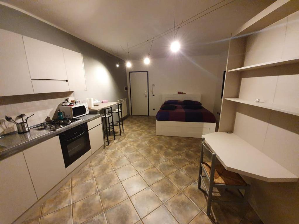 een kleine kamer met een keuken en een bed bij Casa Bach in Piacenza