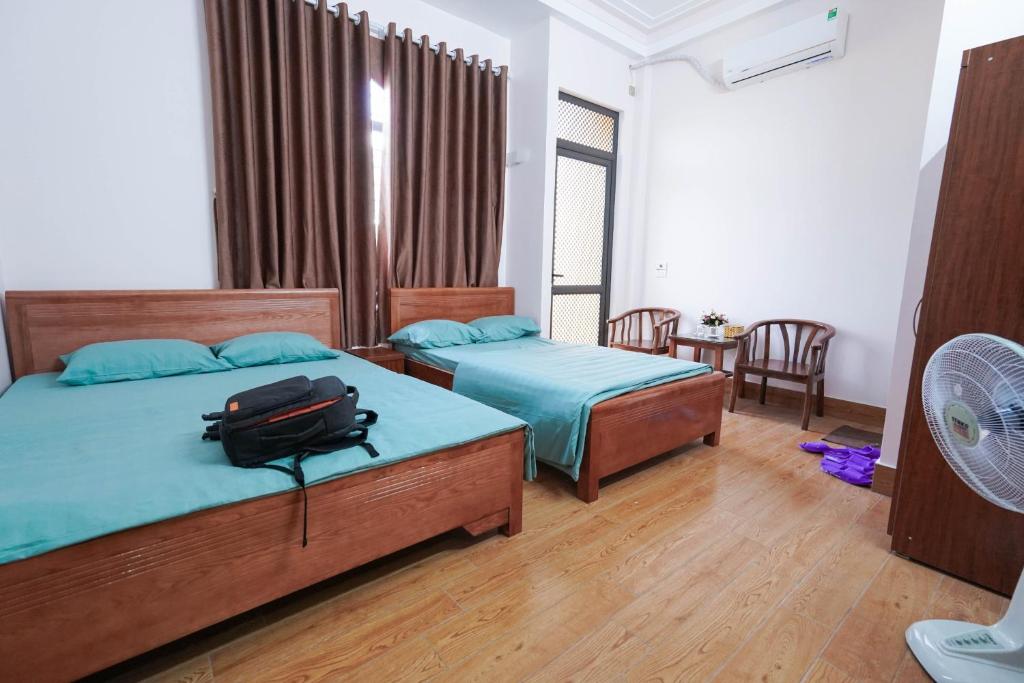 a bedroom with two beds and a backpack on the bed at Motel Xuân Hòa in Bắc Ninh