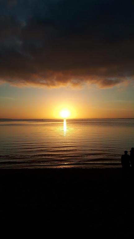 a sunset over the water with the sun in the distance at Mimosas in Andernos-les-Bains