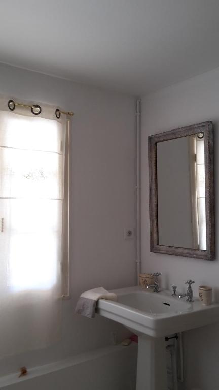 a white bathroom with a sink and a mirror at L&#39;Ecrin in Villeneuve-sur-Lot