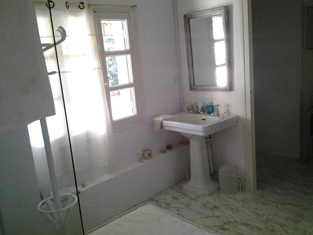 a bathroom with a sink and a tub and a window at L&#39;Ecrin in Villeneuve-sur-Lot