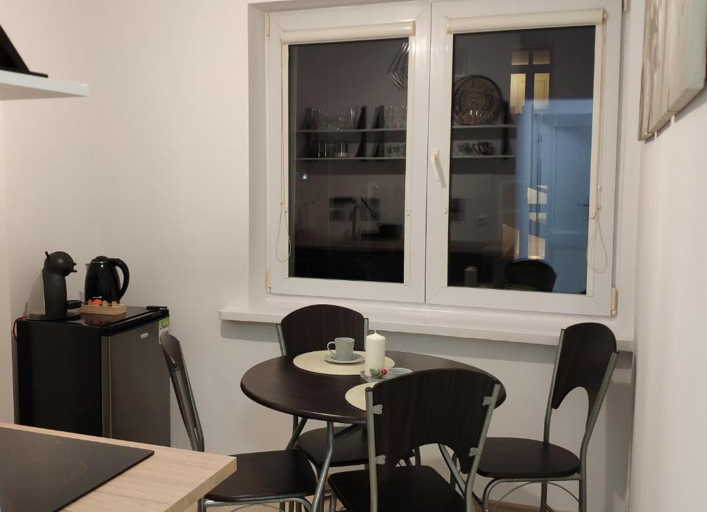 d'une salle à manger avec une table, des chaises et une fenêtre. dans l'établissement Apartament Centrum, à Malbork