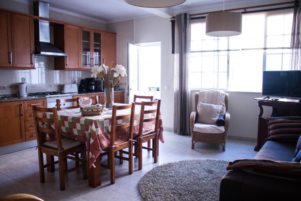 uma cozinha e sala de jantar com mesa e cadeiras em António C em Alvor
