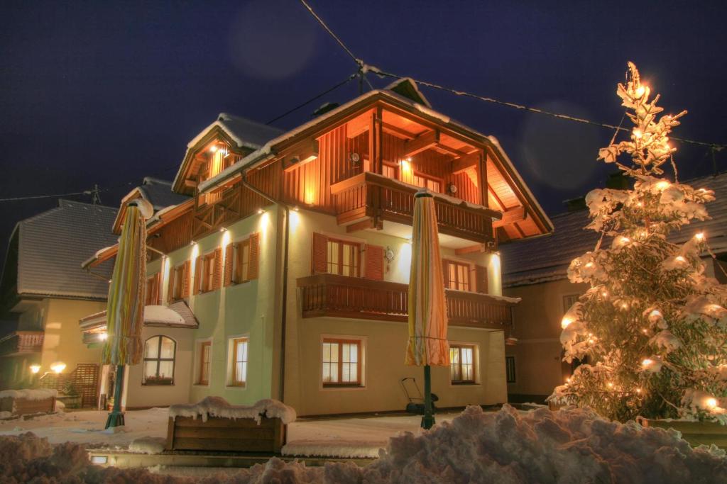 a building with a christmas tree in front of it at Pension Oberjörg in Rattendorf