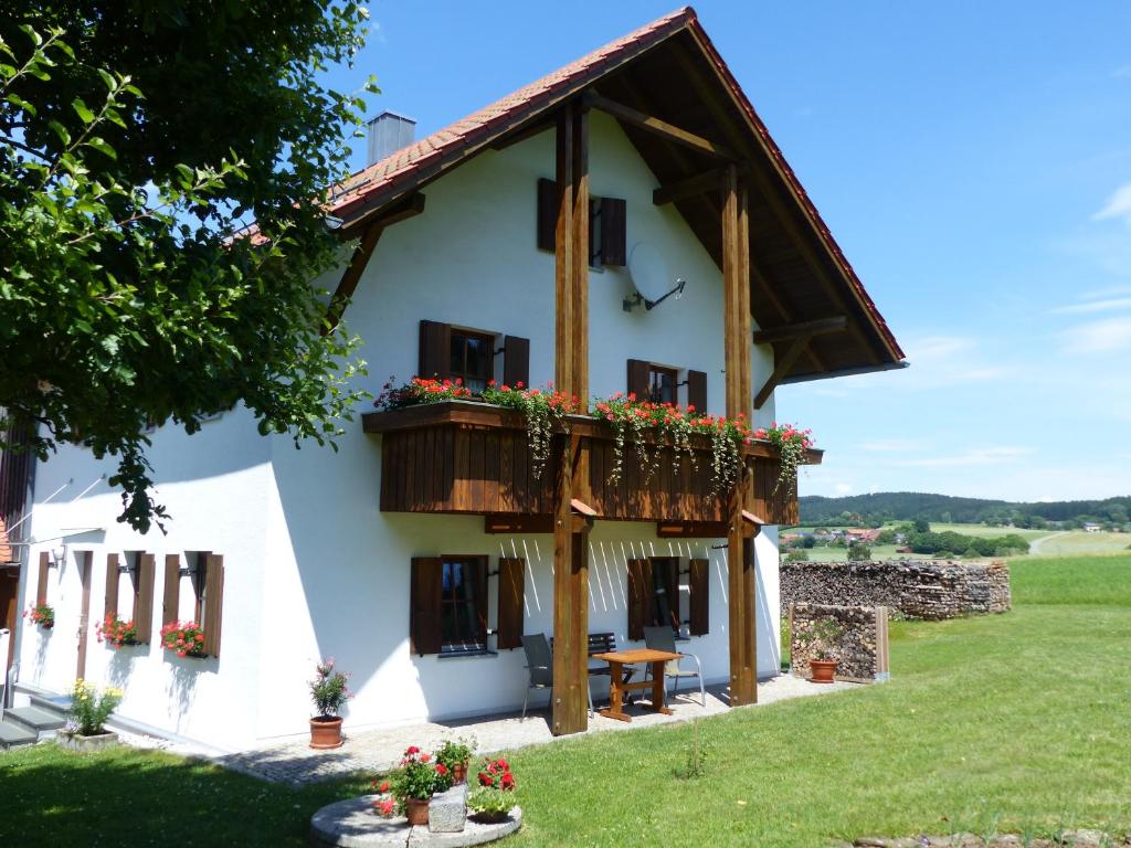 ein Haus mit einem Balkon mit Blumen darauf in der Unterkunft Ferienwohnungen Reitinger in Tiefenbach
