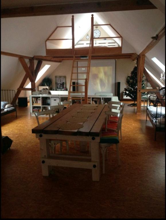 einen großen Tisch in einem Zimmer mit Stühlen und einer Uhr in der Unterkunft Apartmán na horách, Plešivec in Pstruží