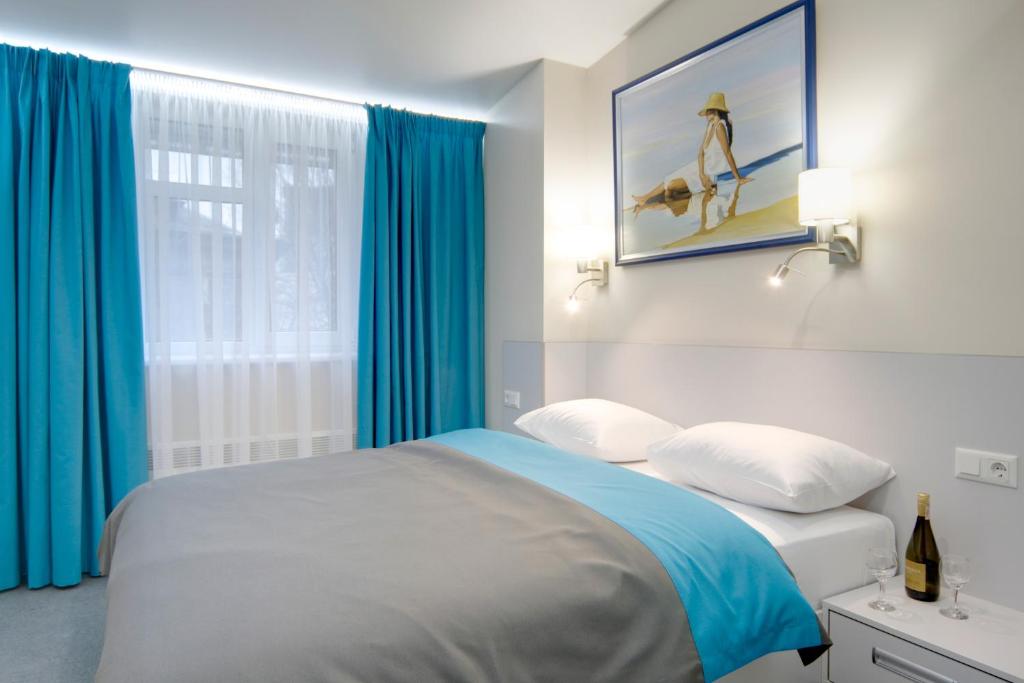 1 dormitorio con 1 cama con cortinas azules en Arena Apartments, en Kiev