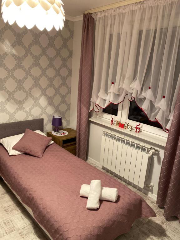 a bedroom with a bed with two towels on it at Apartament w Stolicy Podhala in Nowy Targ