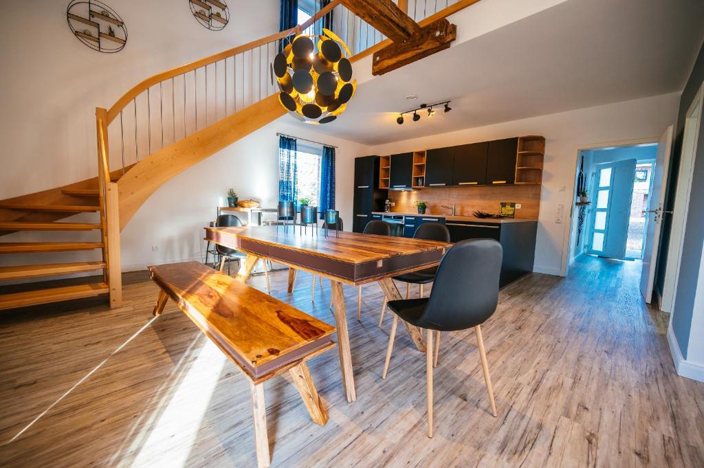 cocina y comedor con mesa de madera y sillas en Ferienhaus Hünzingen № 2, en Walsrode